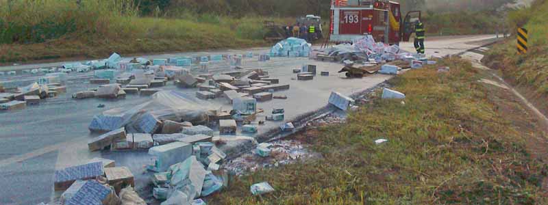 Caminhão tomba e deixa carga de caixas de leite espalhada pela rodovia