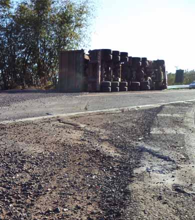 Carreta carregada de pedra tomba após motorista sofrer mal súbito