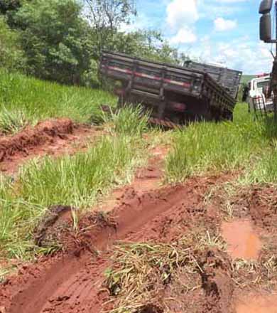 Caminhão fica atolado após caminhoneiro ser obrigado a retirá-lo da pista para evitar colisão
