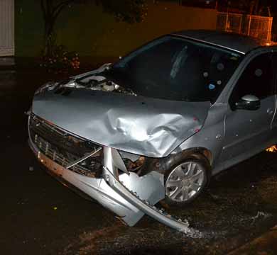 Motorista ignora sinalização e colide contra carro que vai parar em muro de residência