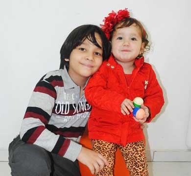 Irmãos posam com as novidades da coleção outono/inverno do Planeta Kids