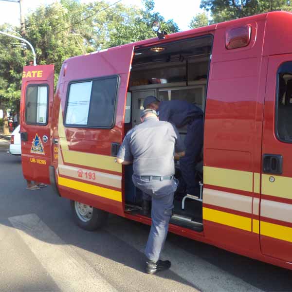 Motociclista é socorrida pela equipe dos bombeiros após colisão em frente ao estádio