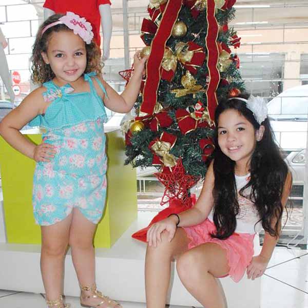 Irmãs fazem poses com os looks do Planeta Kids