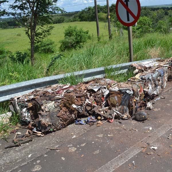 Ao fazer curva, carga de material reciclável prensado cai de carreta