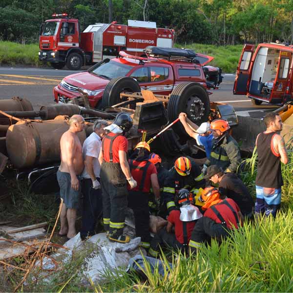 Carreta tomba e motorista fica preso às ferragens no trevo de Oscar Bressane