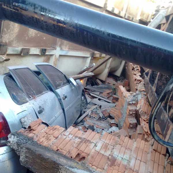 Caminhão carregado com areia tomba sobre residência e danifica carros em Martinópolis