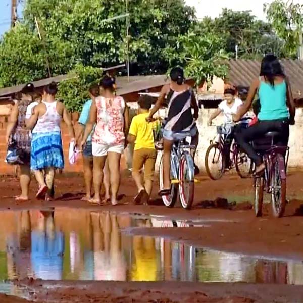 Pais enfrentam lamaçal para levar os filhos para creche em Cândido Mota