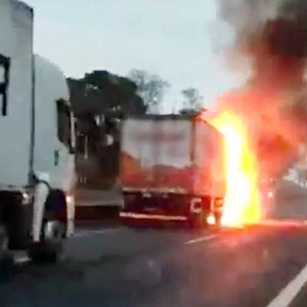 Carro prensado por caminhões pega fogo em rodovia e motoristas escapam ilesos